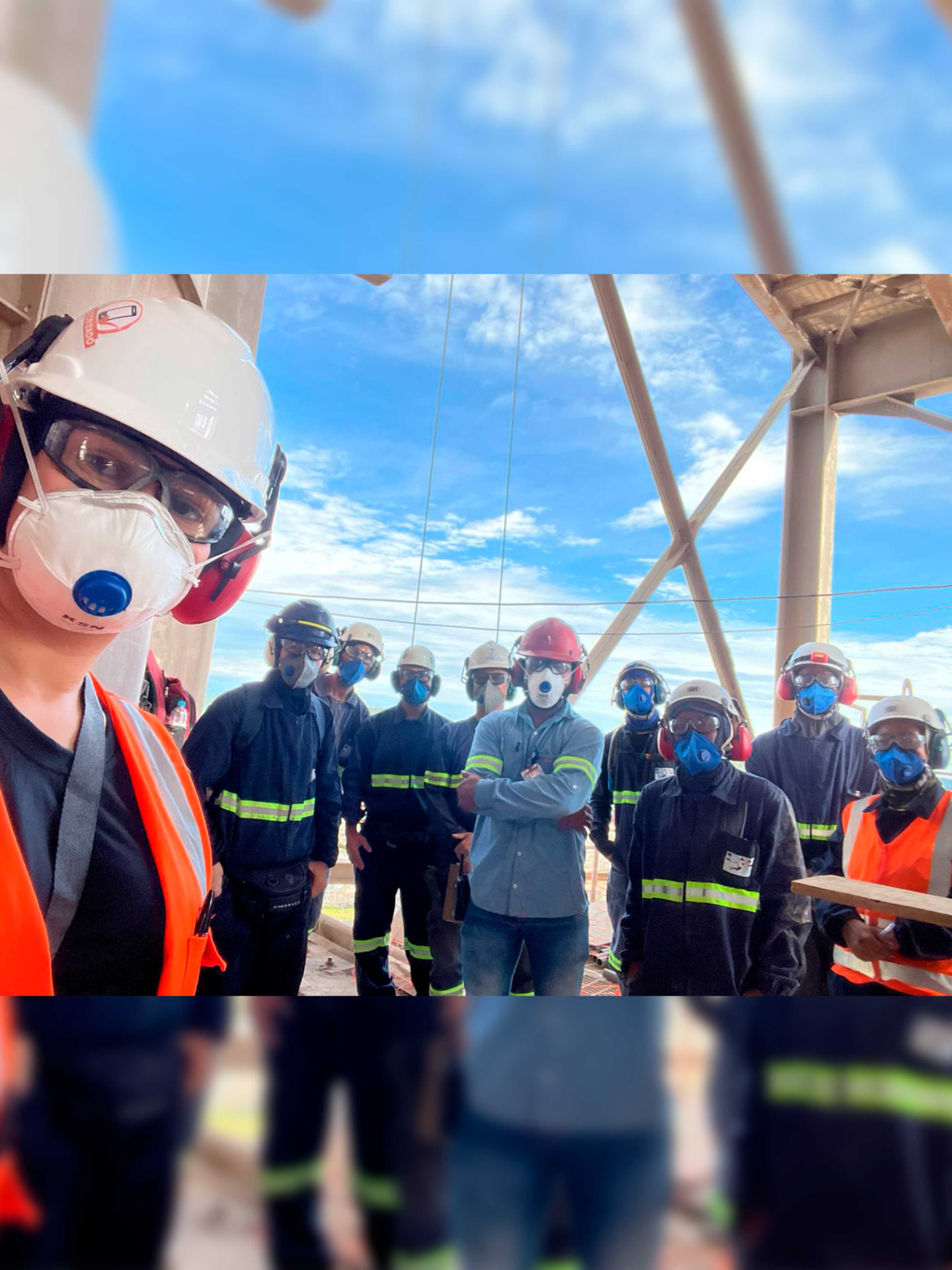 Equipe técnica com EPI reunida em área externa de planta industrial